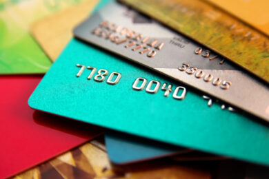 stack of brightly colored credit card debt on desk